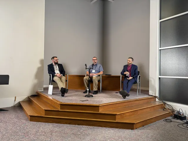 The debate panel seated together on the platform