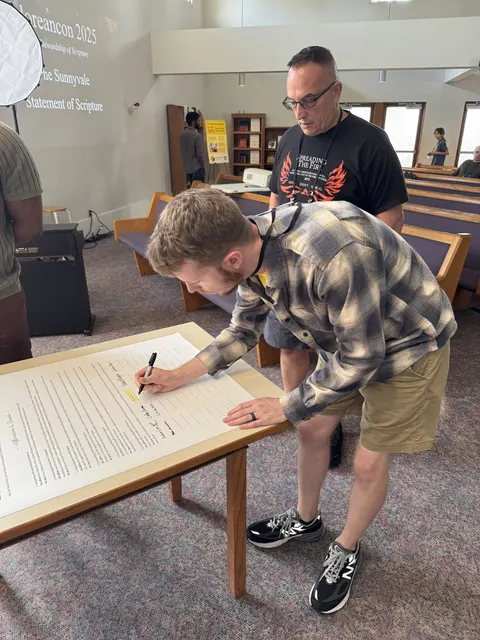 An attendee leaning in to sign the statement
