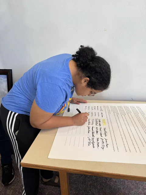One of the youngest attendees signing the statement